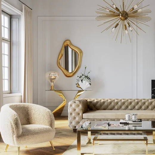 In diesem bild sieht man einen hellen stoff KARE sessel und eine beige KARE -Couch und mehrere goldene Dekoartikel