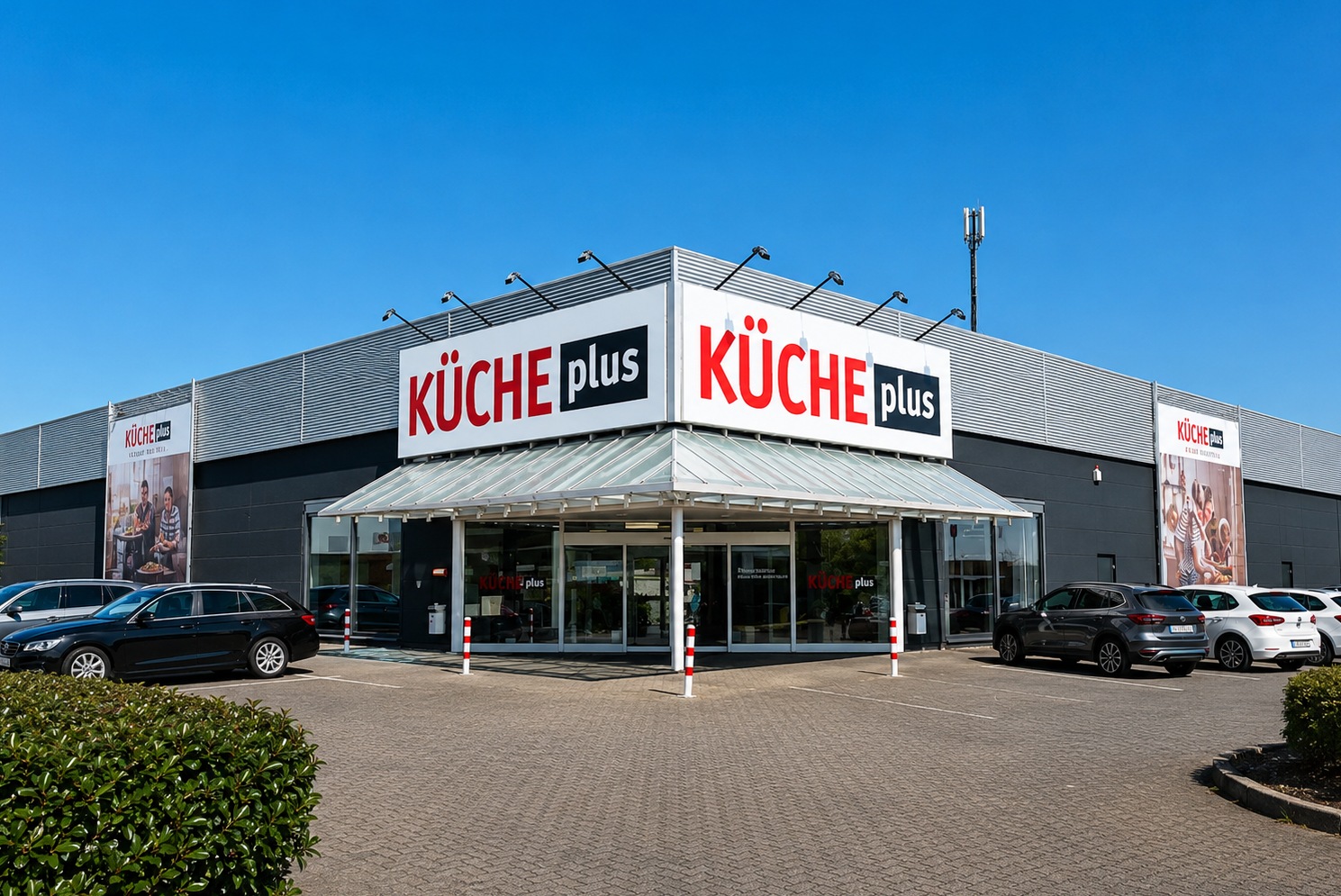Außenansicht des Küche-Plus-Fachgeschäfts mit Eingangsbereich und Firmenbeschilderung.